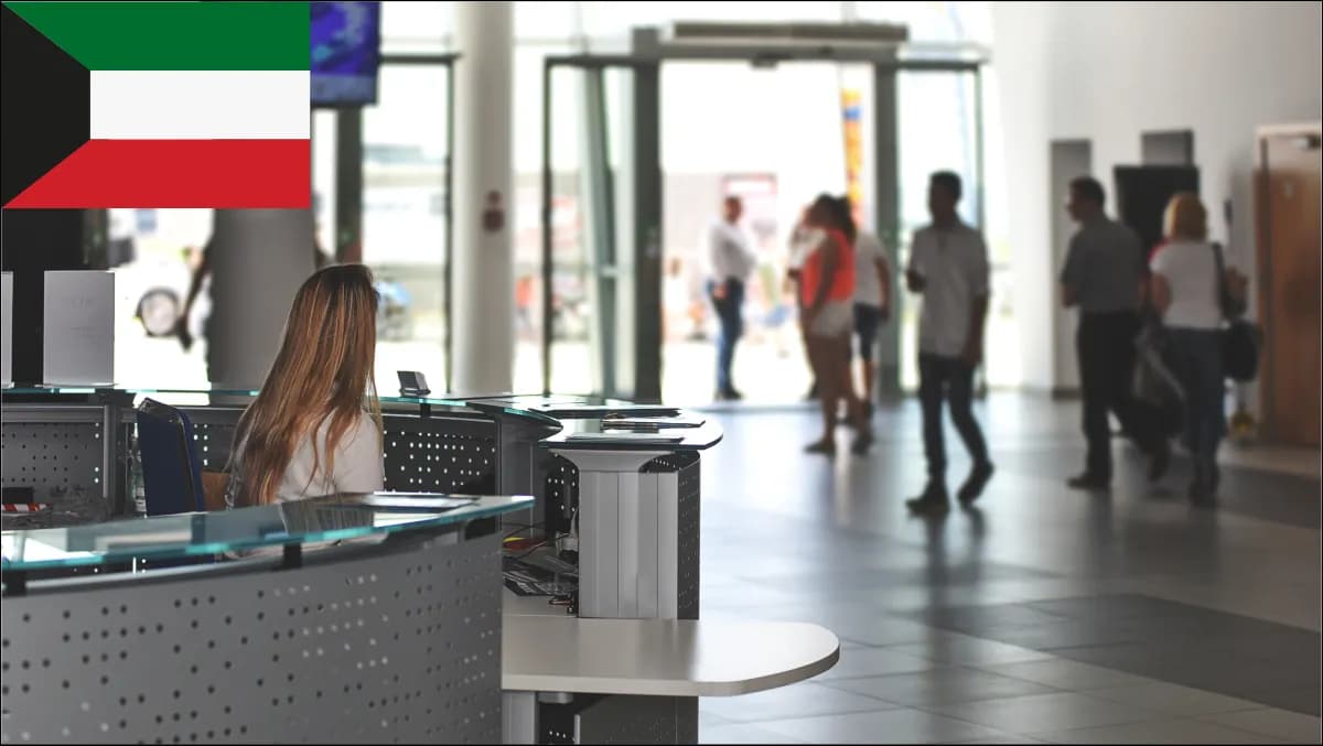 A reception lobby in a Kuwait City corporate tower with a bilingual EN+AR self-service visitor kiosk, security gates and a host-notification screen.